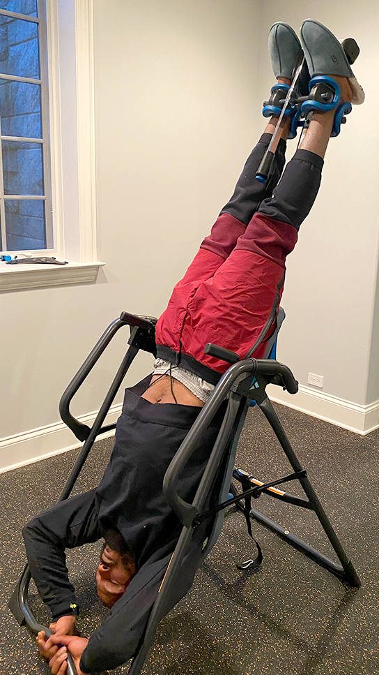 Teeter FitSpine Happy Back Club - person on inversion table in home