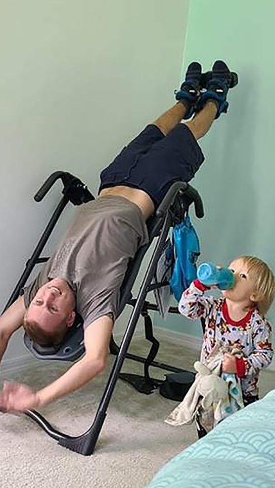 Teeter FitSpine Happy Back Club - person on inversion table in bedroom