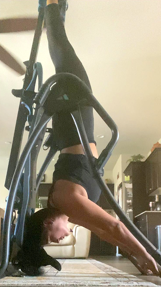 Teeter FitSpine Happy Back Club - person on inversion table in living room