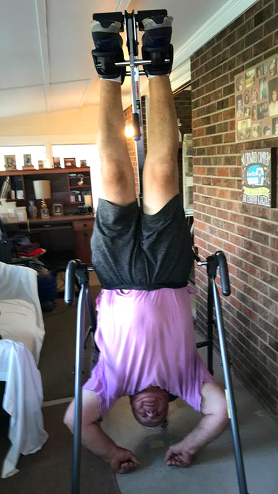 Teeter FitSpine Happy Back Club - person on inversion table in room