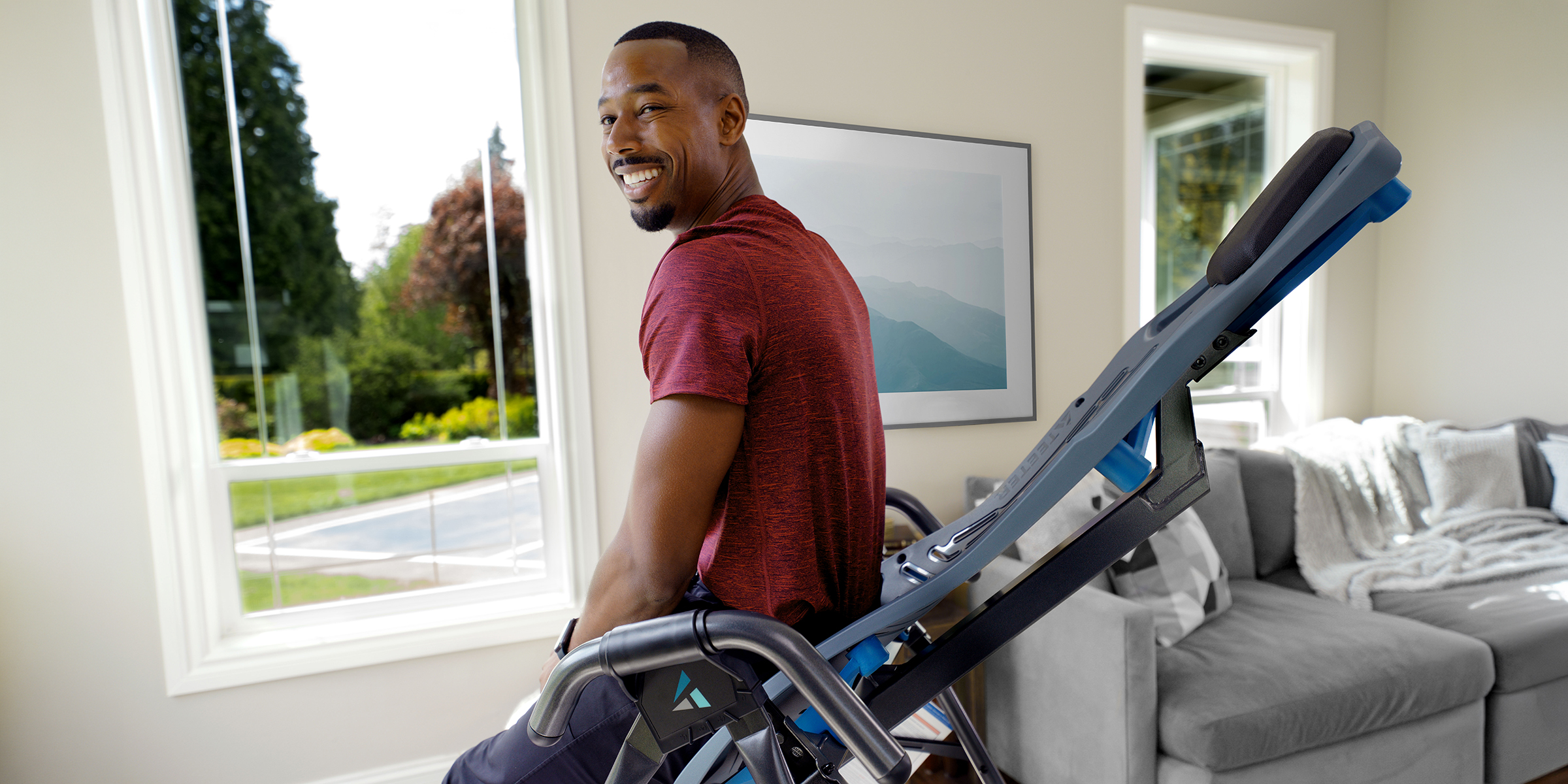 Man on a Teeter inversion table in a bright living room