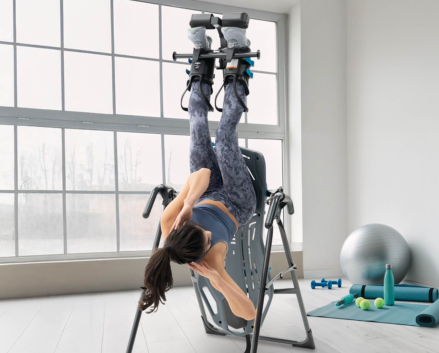 Person doing crunches on Teeter Inversion Table with Gravity Boots and Adapter Kit