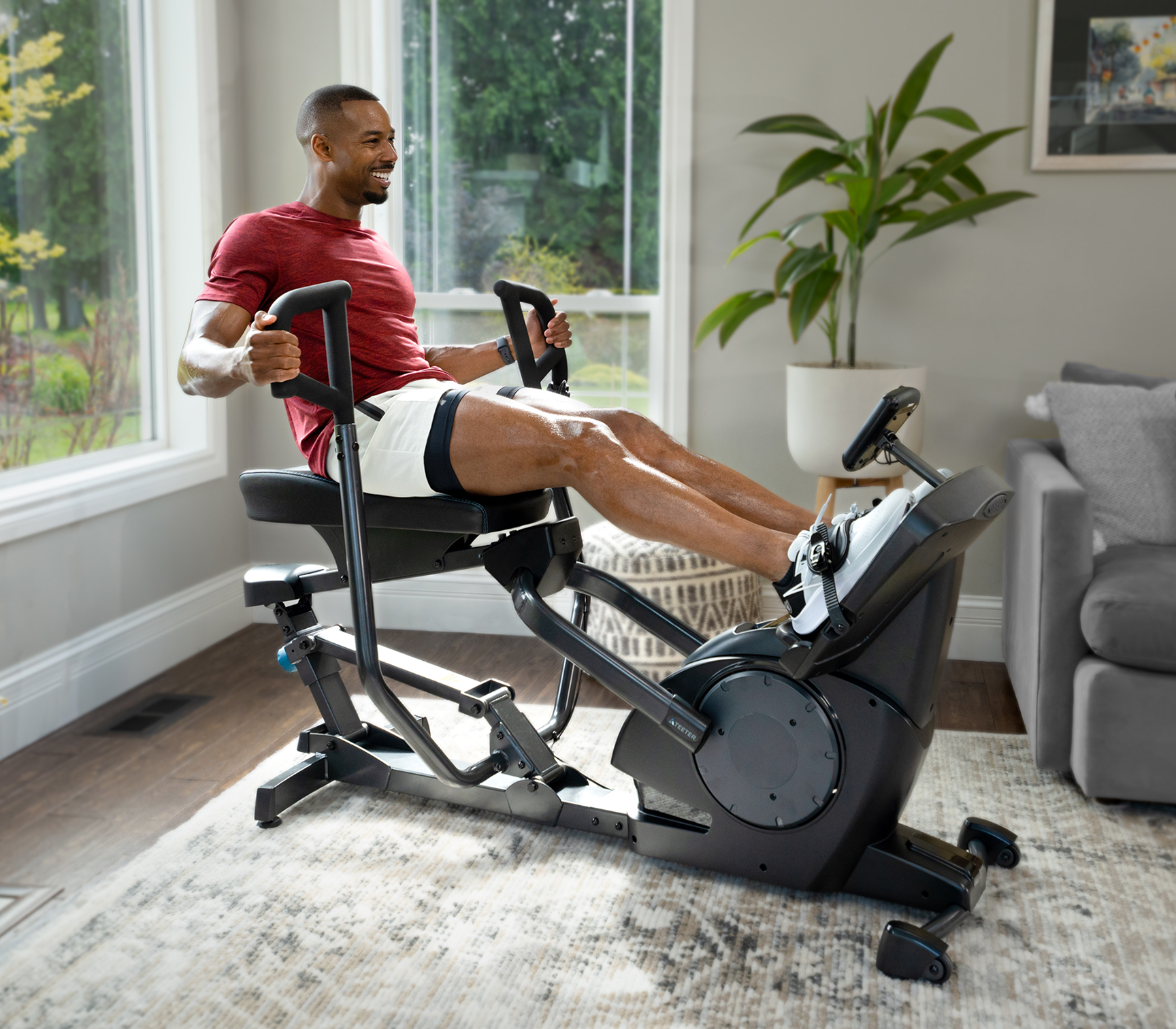 Man using Power10 elliptical rower at home