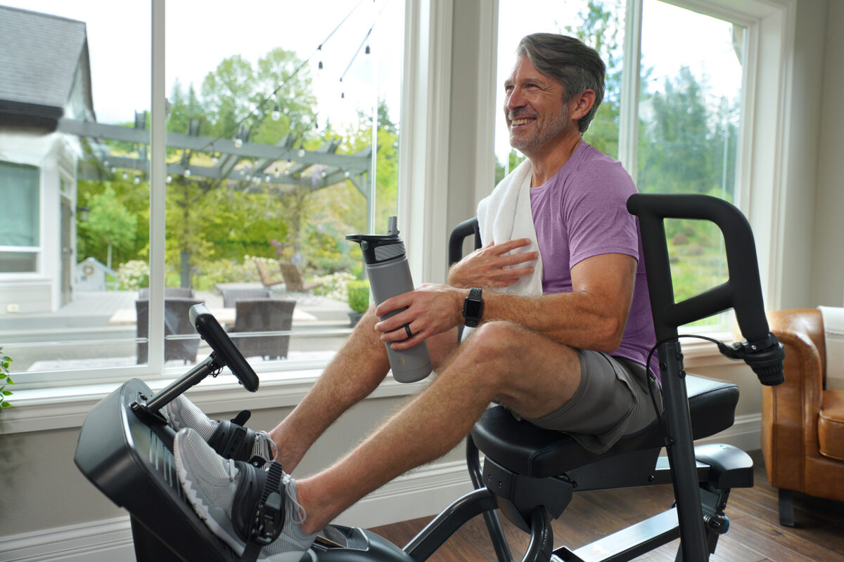 Man relaxing at home on a Teeter FreeStep recumbent cross trainer